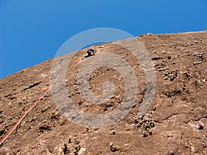Rock climber climbing a sloping rock wall