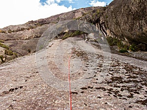 Rock climber climbing a sloping rock wall in Brazil