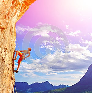 Rock climber climbing up a cliff