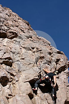 Rock climber in dyno move