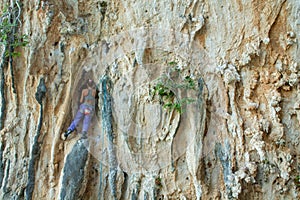 Rock climber girl on challenging overhanging tufa climbing route in Kalymnos, Greece