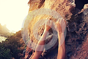 Rock climber hands climbing at seaside mountain cliff rock