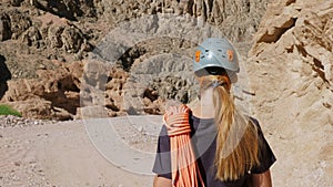 Rock climber in a helmet goes along a canyon