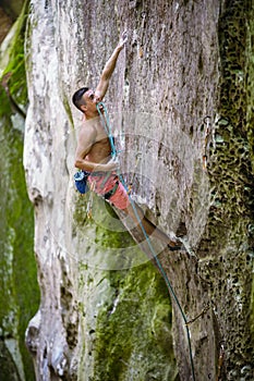 Rock climber holding rope with teeth before making clip