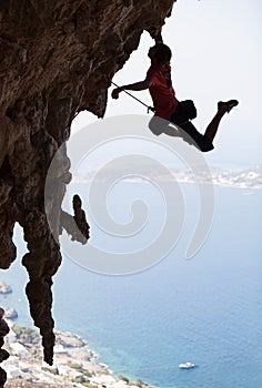 Rock climber jumping on next handhold