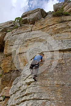 Rock climber looks down with smile