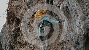 Rock climber on overhanging cliff. Male climber trying hard to grip handholds on tufas on challenging route and