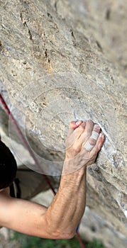 Rock climber's hand grasping handhold on cliff