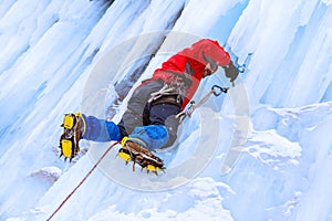 Rock climber screwing ice into glacier surface