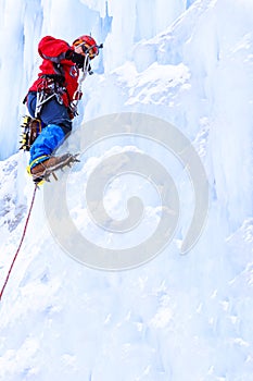 Rock climber screwing ice into glacier surface