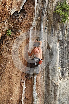 Rock climber struggling on his way up to the top