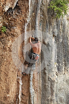 Rock climber struggling to make next movement