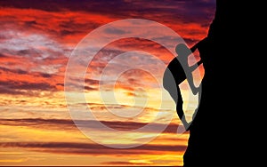 Rock climber at sunset background.