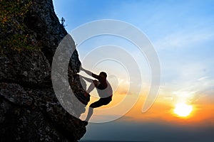 Rock climber at sunset background. Sport and active life