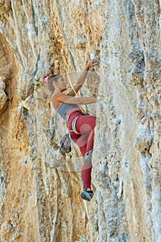 Rock climber on tufas climbing route in Kalymnos, Greece