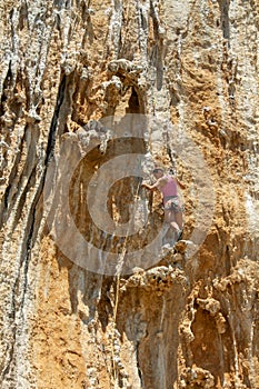 Rock climber on tufas climbing route in Kalymnos, Greece