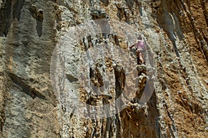 Rock climber on tufas climbing route in Kalymnos, Greece