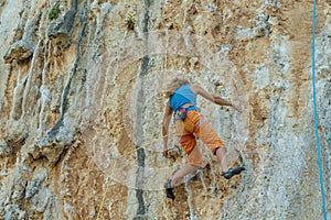 Rock climber on tufas climbing route in Kalymnos, Greece