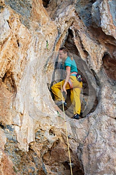 Rock climber on tufas climbing route in Kalymnos, Greece