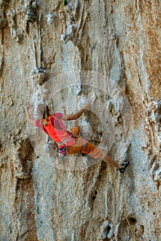 Rock climber on tufas climbing route in Kalymnos, Greece