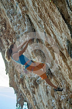 Rock climber on tufas climbing route in Kalymnos, Greece