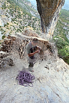 Rock climber winding a rope after ascent