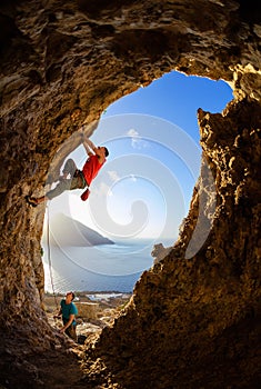 Rock climbers challenging route in cave