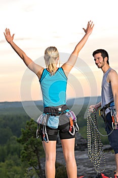 Rock climbing cheerful alpiners on top sunset