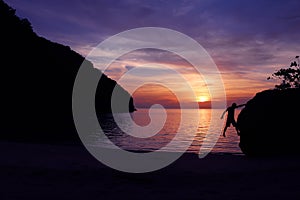 Rock climbing with sunset on the beach.