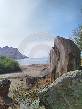 Rock in coastal with blue seawater and hill in Manatuto, Timor-Leste. photo