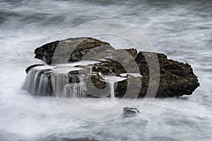 Rock covered in sea water after a wave cradhed on it at Pancake rocks, New Zealand