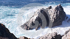 Rock crag of cliff, ocean beach, Point Lobos, California coast. Waves crashing.