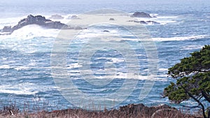 Rock crag of cliff, ocean beach, Point Lobos, California coast. Waves crashing.