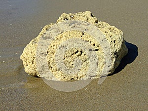 Rock in fine sand with interesting texture photo