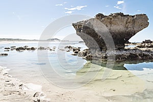 Rock formation with reflection and light clear oceanwater at Peterborough beach, Victoria, Australia