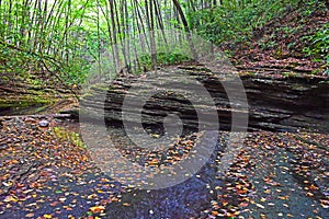 Rock formations along a slow river bed in summer.