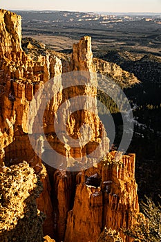 Rock formations in foreground with forest below and behind shot with a zoom shot of bryce canyon national park of the hoodoos at i