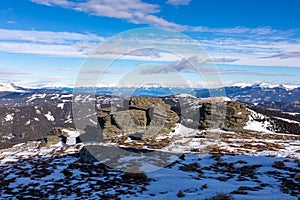 Rock formations with scenic view on snowcapped Ameringkogel on Packalpe seen from Steinerne Hochzeit in Saualpe mountains photo