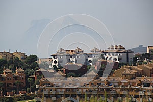 Rock of Gibraltar on a hazy day with houses in the foreground