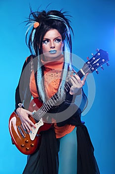 Rock girl plating on electric guitar on blue background