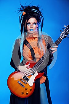 Rock girl posing with electric guitar playing hard-rock