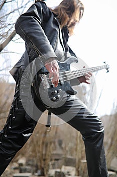 Rock guitarist on the steps. A musician with a bass guitar in a