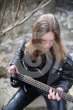 Rock guitarist on the steps. A musician with a bass guitar in a