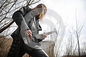 Rock guitarist on the steps. A musician with a bass guitar in a