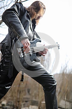 Rock guitarist on the steps. A musician with a bass guitar in a