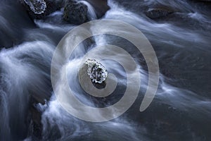 Rock with ice in streaming water