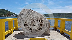 Rock with inscription and yellow cement railing and sea water in Guanica, Puerto Rico photo