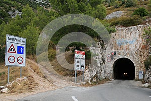 The rock leading through the Pitve tunnel in Ivan Dolac, Croatia. On the sign is the inscription Pitve tunnel and checked