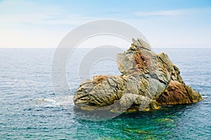 Rock like lying dog in the Mediterranean Sea in cloudy weather in Lloret de Mar, Costa Brava