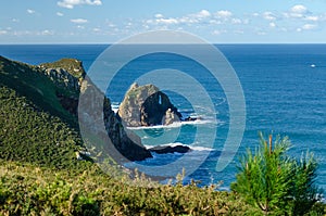 Rock in the middle of the Atlantic Ocean with a hole caused by water erosion